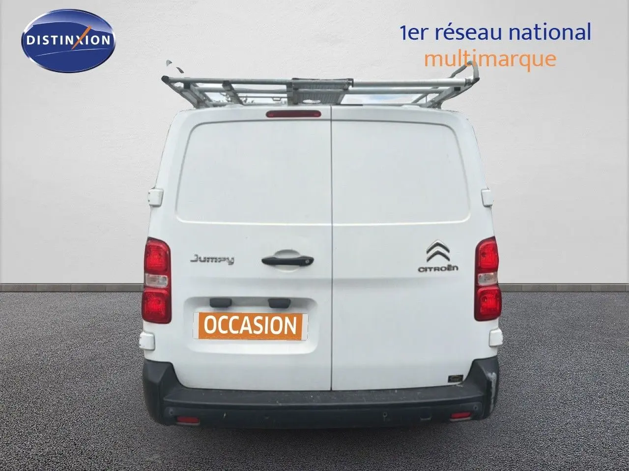 Vue arrière d’un utilitaire Citroën Jumpy blanc avec galerie de toit et plaque « OCCASION » visible.