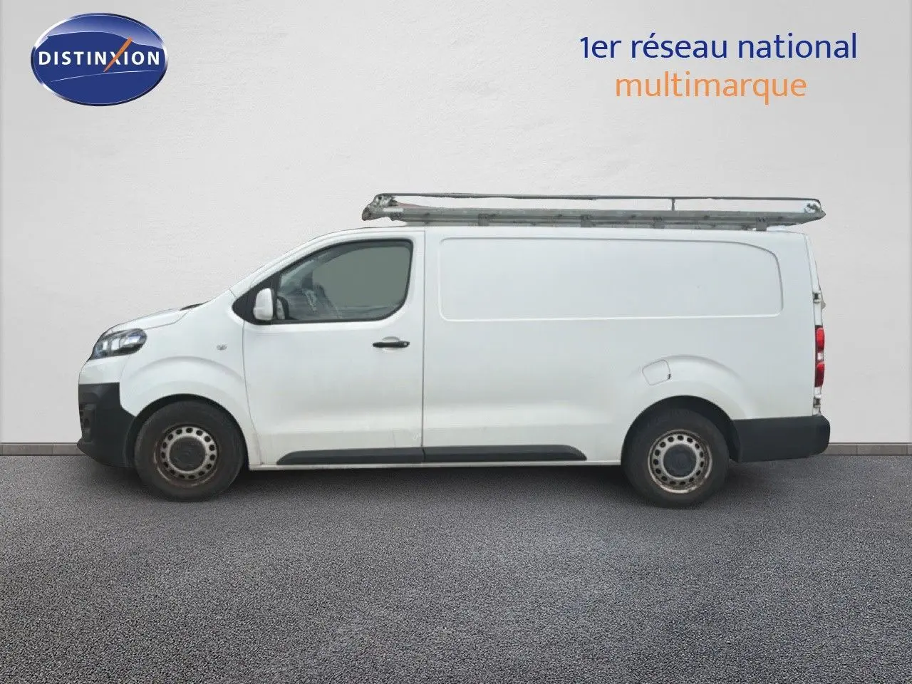 Vue latérale droite d’un utilitaire Citroën Jumpy XL blanc avec galerie de toit métallique.