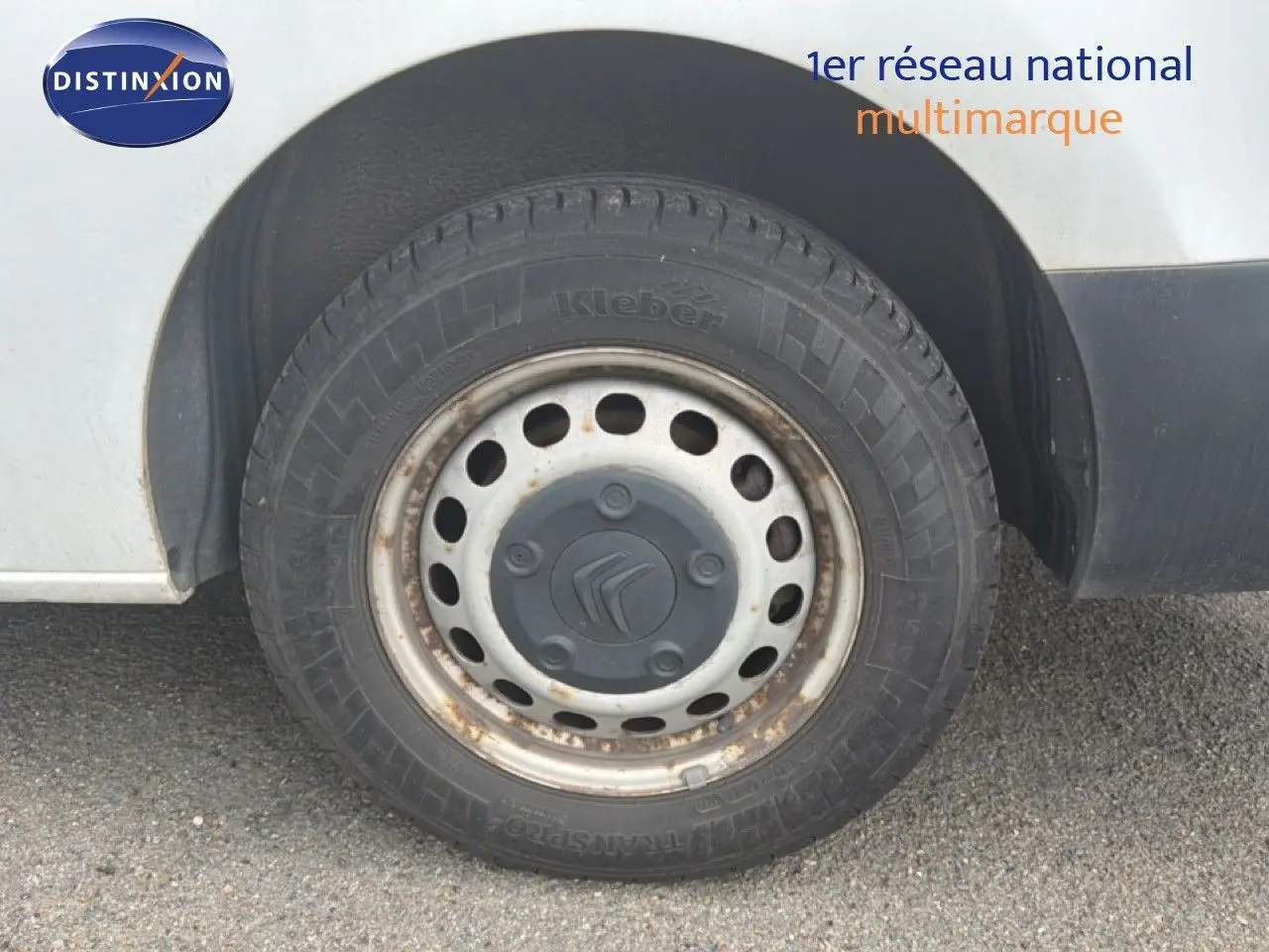 Gros plan sur la roue avant gauche d’un Citroën Jumpy blanc de 2017, jante acier avec traces de rouille.
