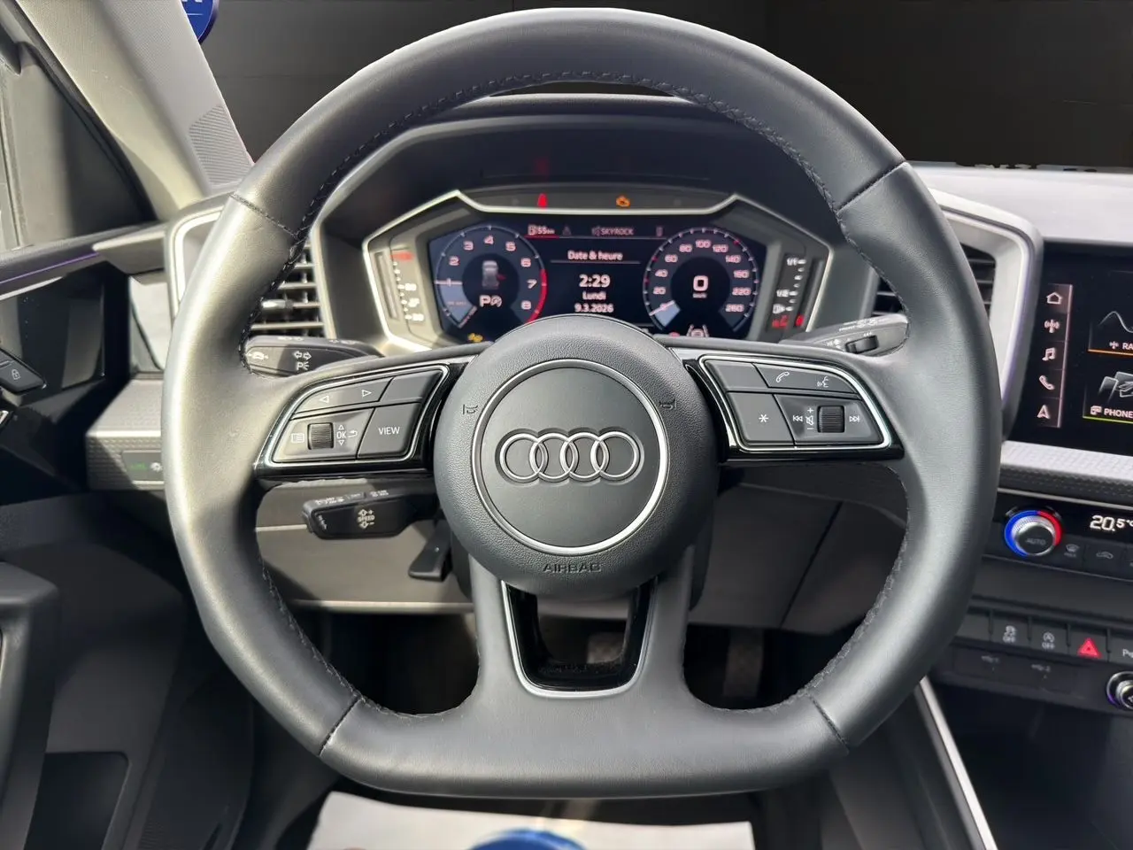 Vue frontale du volant en cuir noir de l'Audi A1 Sportback 2025 avec tableau de bord numérique et commandes intégrées.