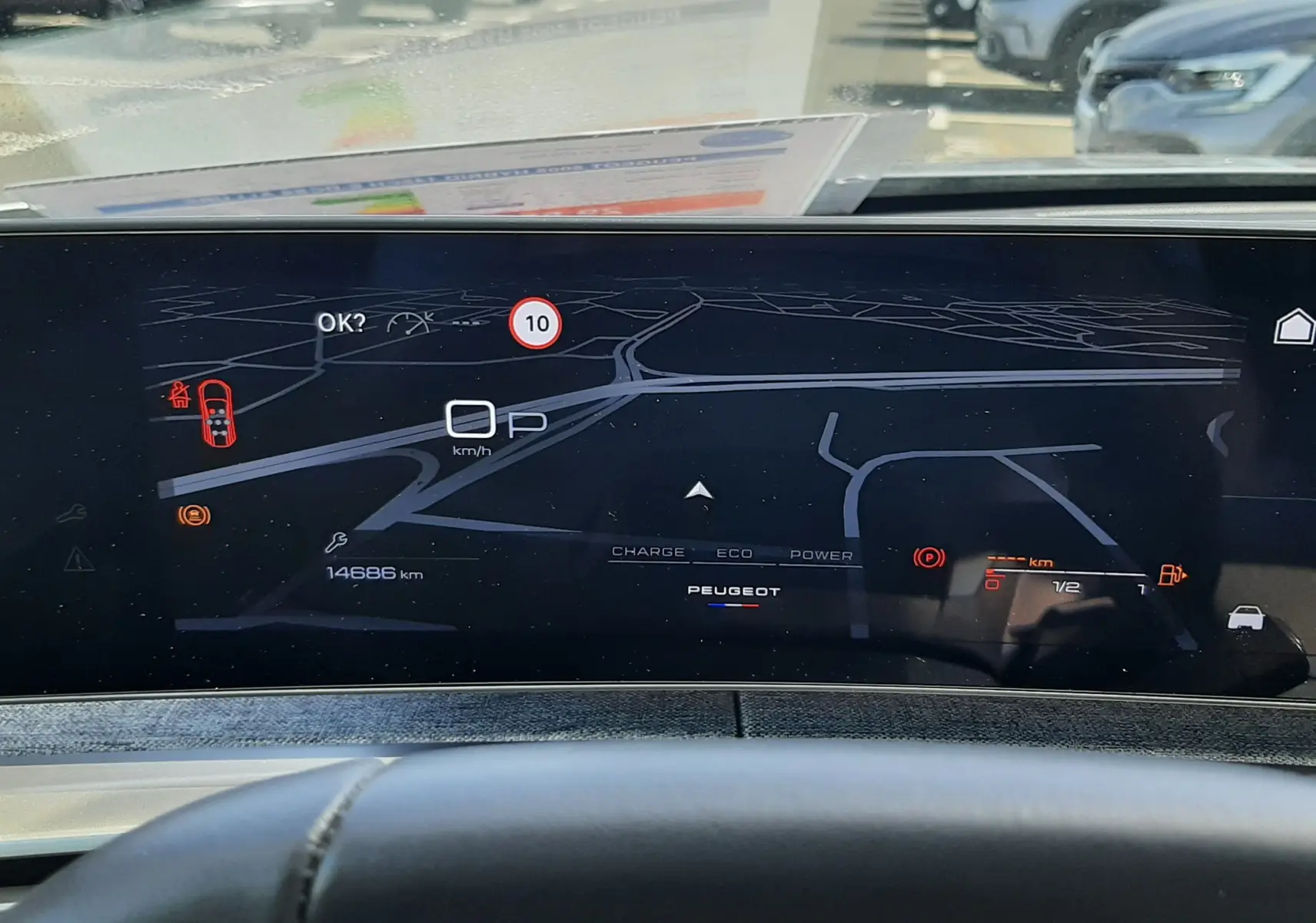 Vue intérieure du tableau de bord numérique du Peugeot 5008 Hybrid 2025, affichant la navigation et les alertes de conduite.