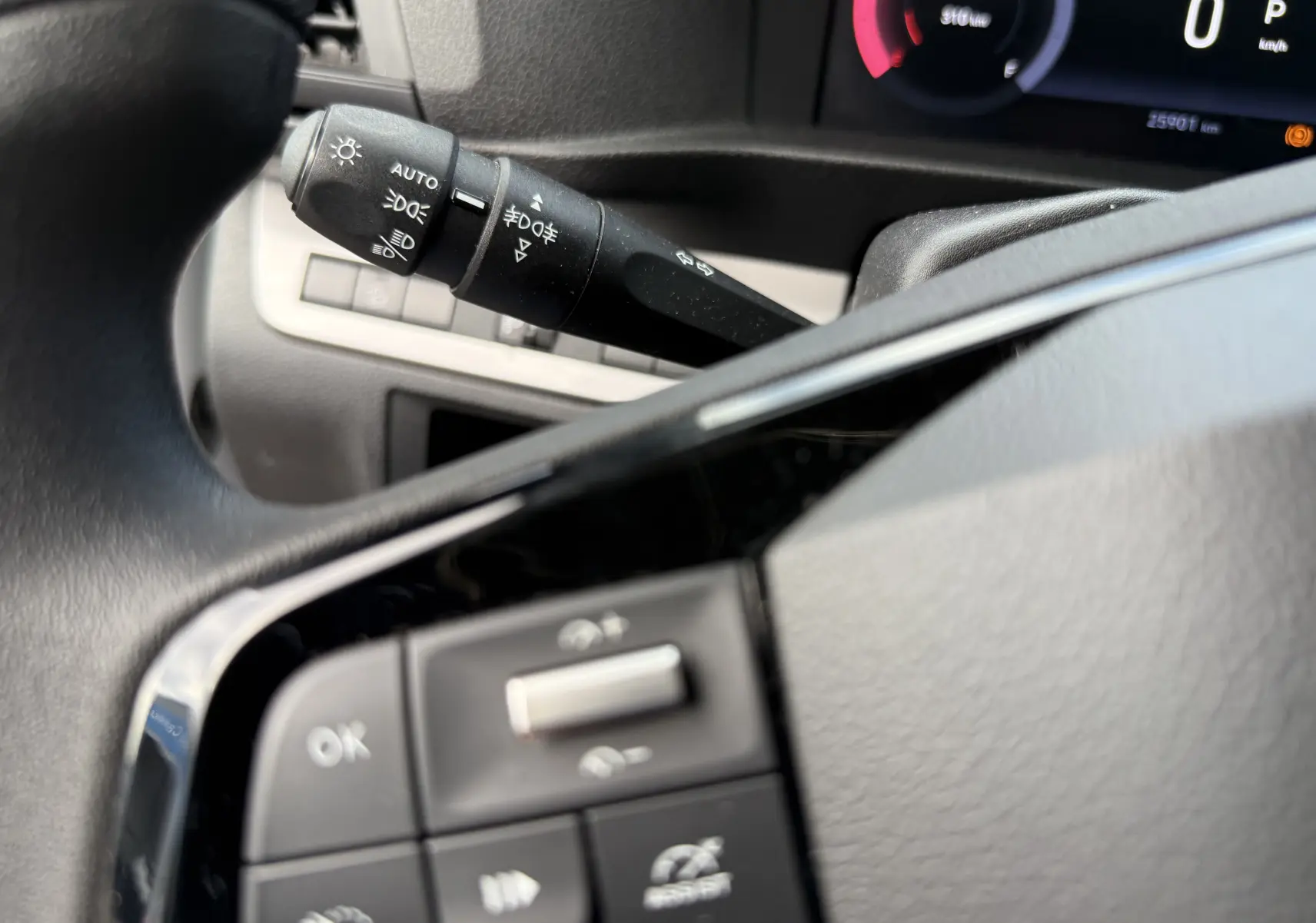 Gros plan sur la commande des feux et les boutons du volant du FIAT Scudo Fourgon blanc, tableau de bord partiellement visible.