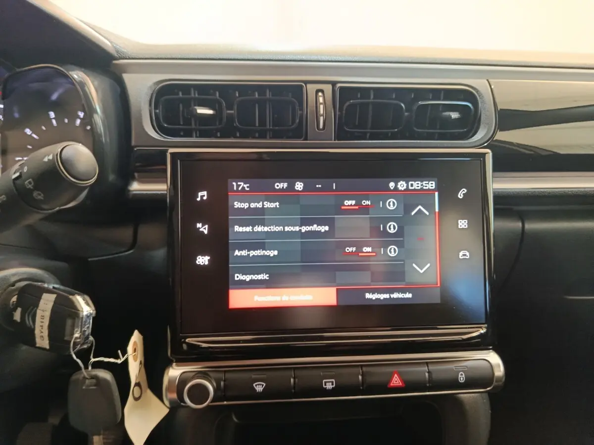 Vue rapprochée de l’écran tactile central et des commandes du tableau de bord d’une Citroën C3 gris foncé 2024.