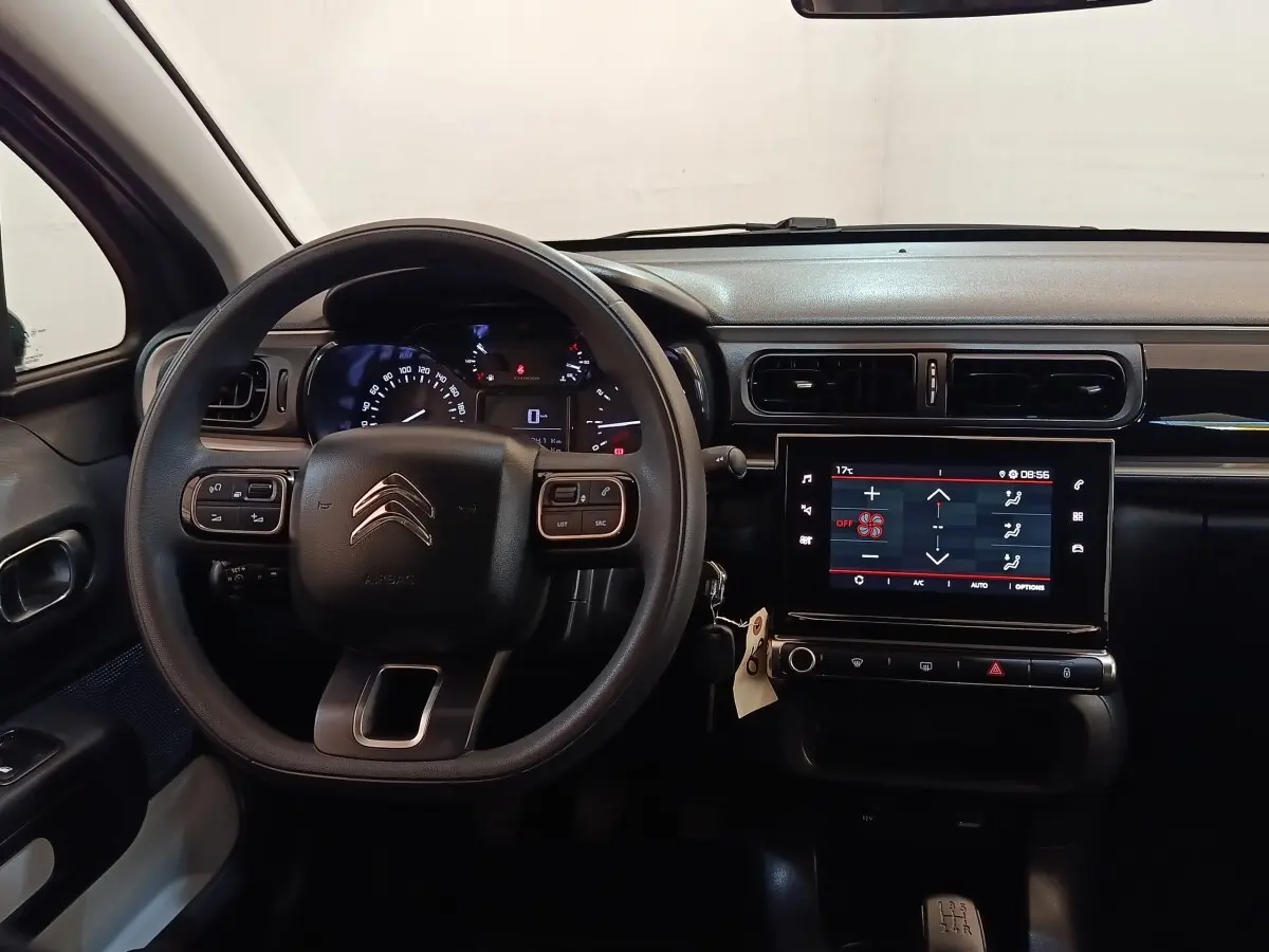 Vue intérieure frontale du tableau de bord et volant noir de la Citroën C3 PureTech 83 BVM PLUS 2024.