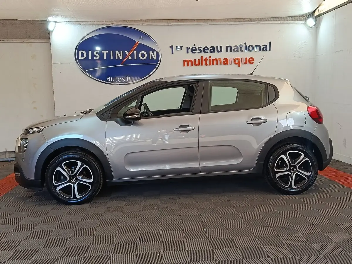 Vue de profil côté gauche d'une Citroën C3 gris foncé 2024 avec jantes alliage et poignées ton caisse.