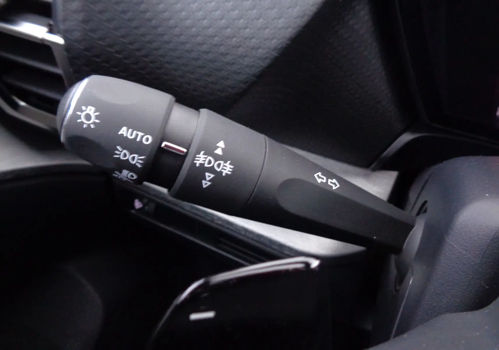 Gros plan sur la commande de phares et clignotants noire dans l’habitacle du Citroën C5 X noir métal 2023.
