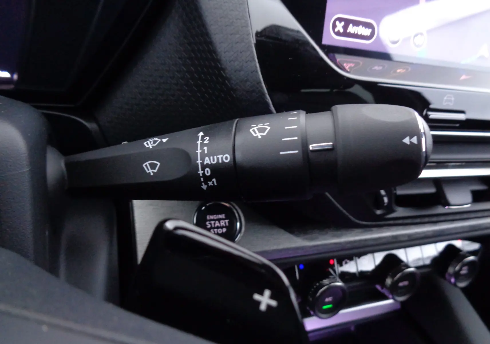 Gros plan sur la commande d’essuie-glace à gauche du volant dans l’habitacle noir du Citroën C5 X 2023.