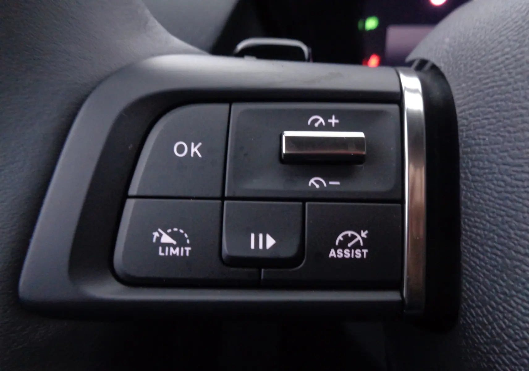 Gros plan sur les commandes au volant gauche du Citroën C5 X noir métal, avec boutons de limitation et assistance de vitesse.
