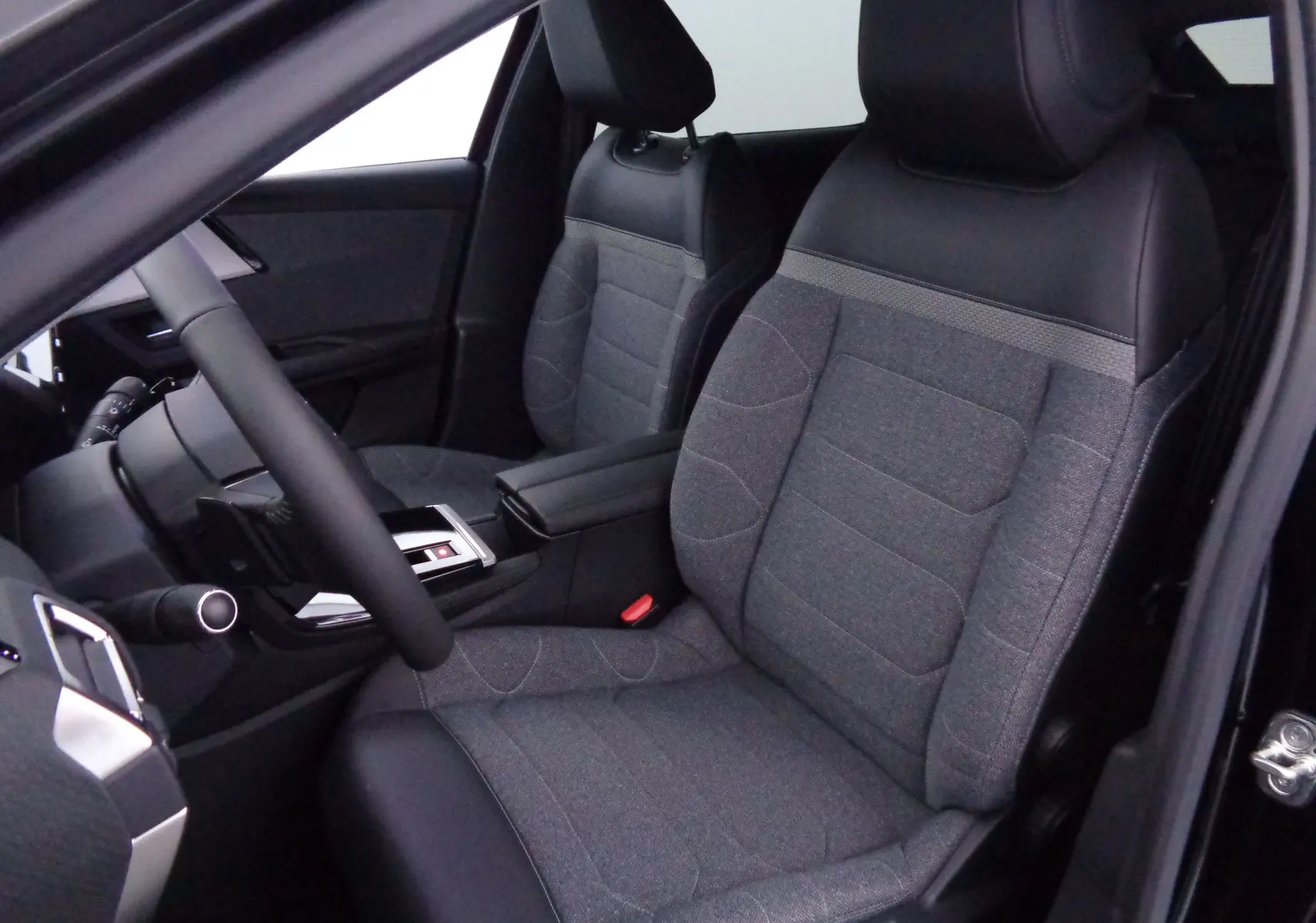 Vue intérieure côté gauche montrant les sièges avant en tissu gris et cuir noir du Citroën C5 X noir métal 2023.
