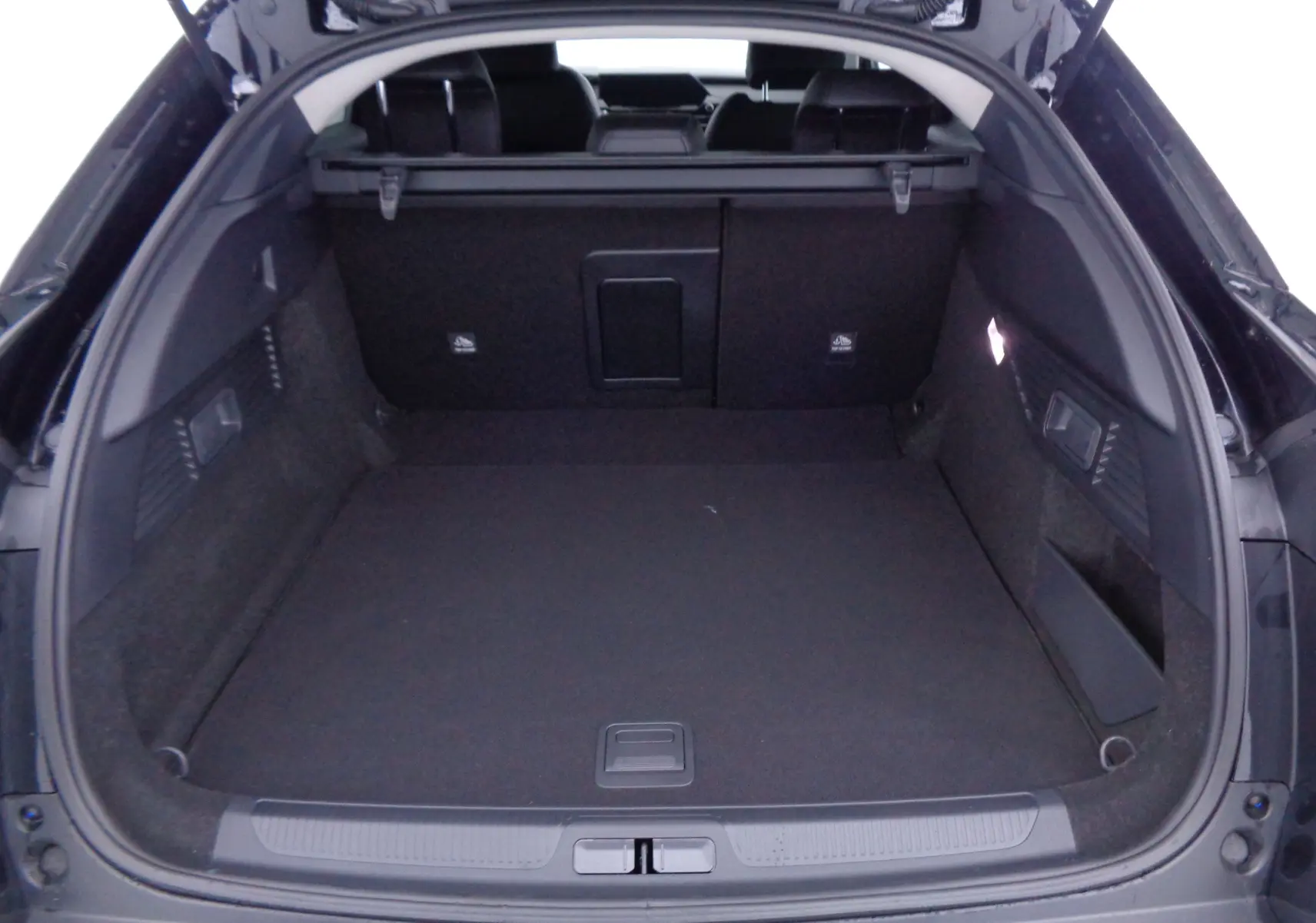 Coffre ouvert d'une Citroën C5 X noire métal 2023, vue arrière montrant un espace de chargement spacieux et propre.