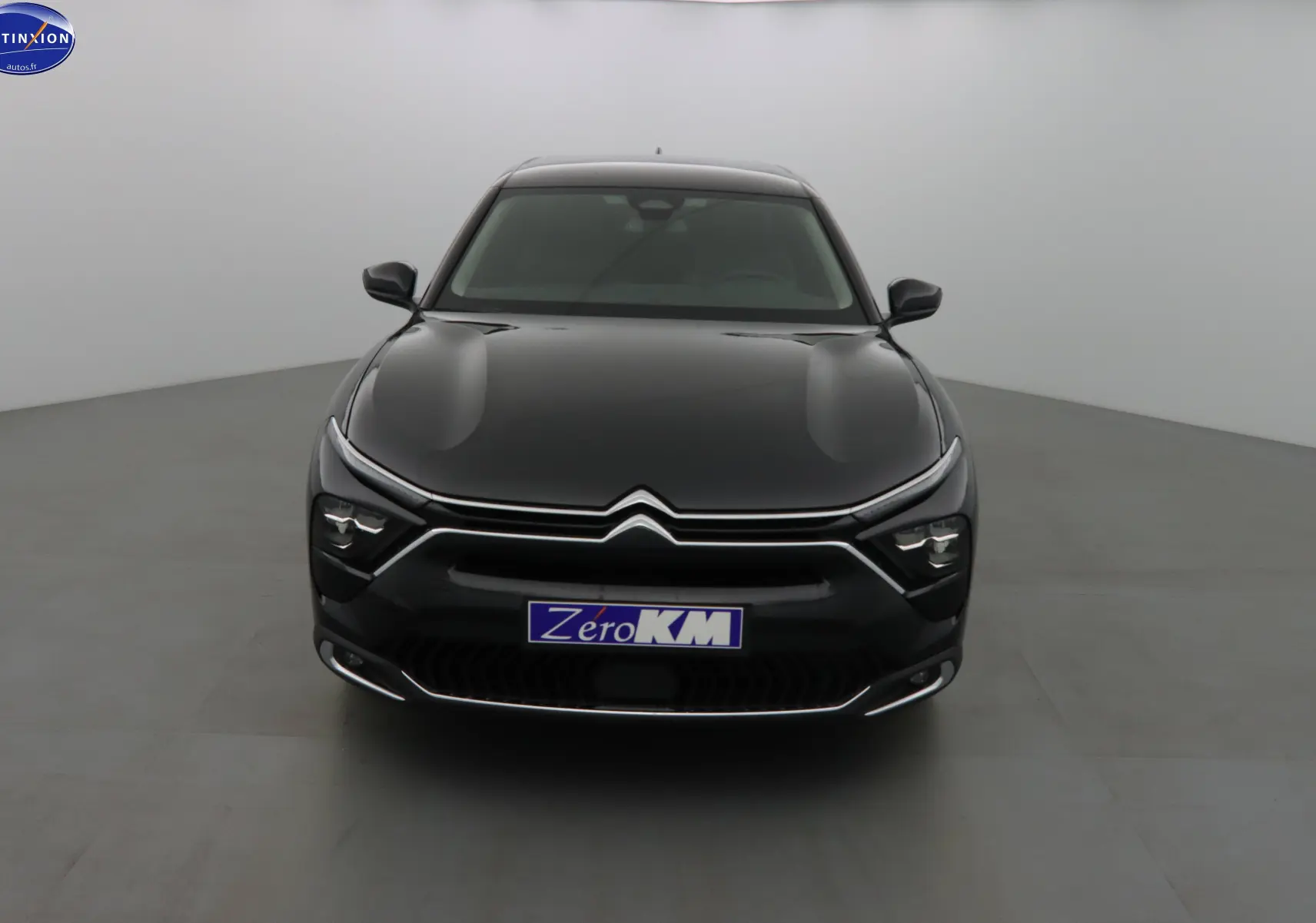 Vue frontale d'une Citroën C5 X noire métal avec signature lumineuse LED et calandre chromée distinctive.