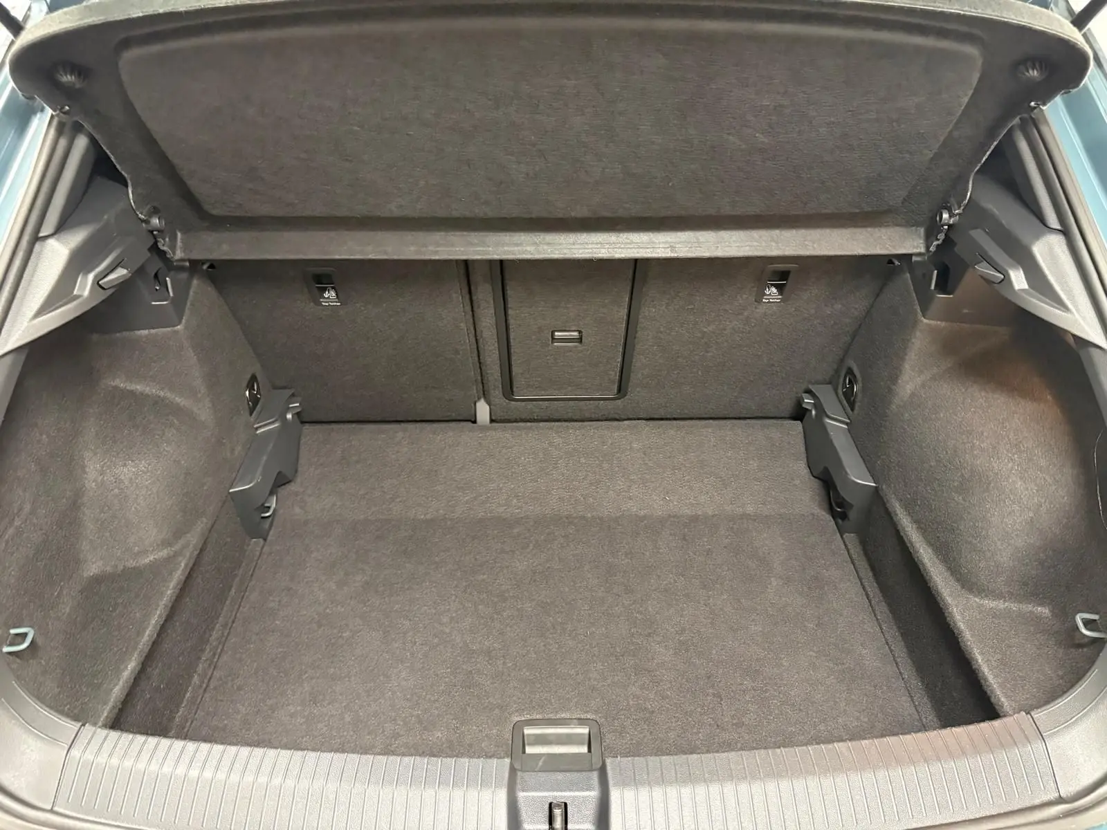 Coffre ouvert du Volkswagen T-Roc 2024, vue intérieure, montrant un espace de chargement propre et bien agencé.