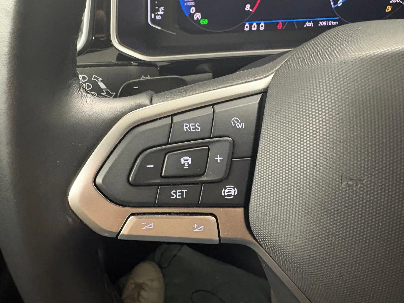 Gros plan sur les commandes au volant du Volkswagen T-Roc 2024, version R-Line, avec tableau de bord numérique visible.
