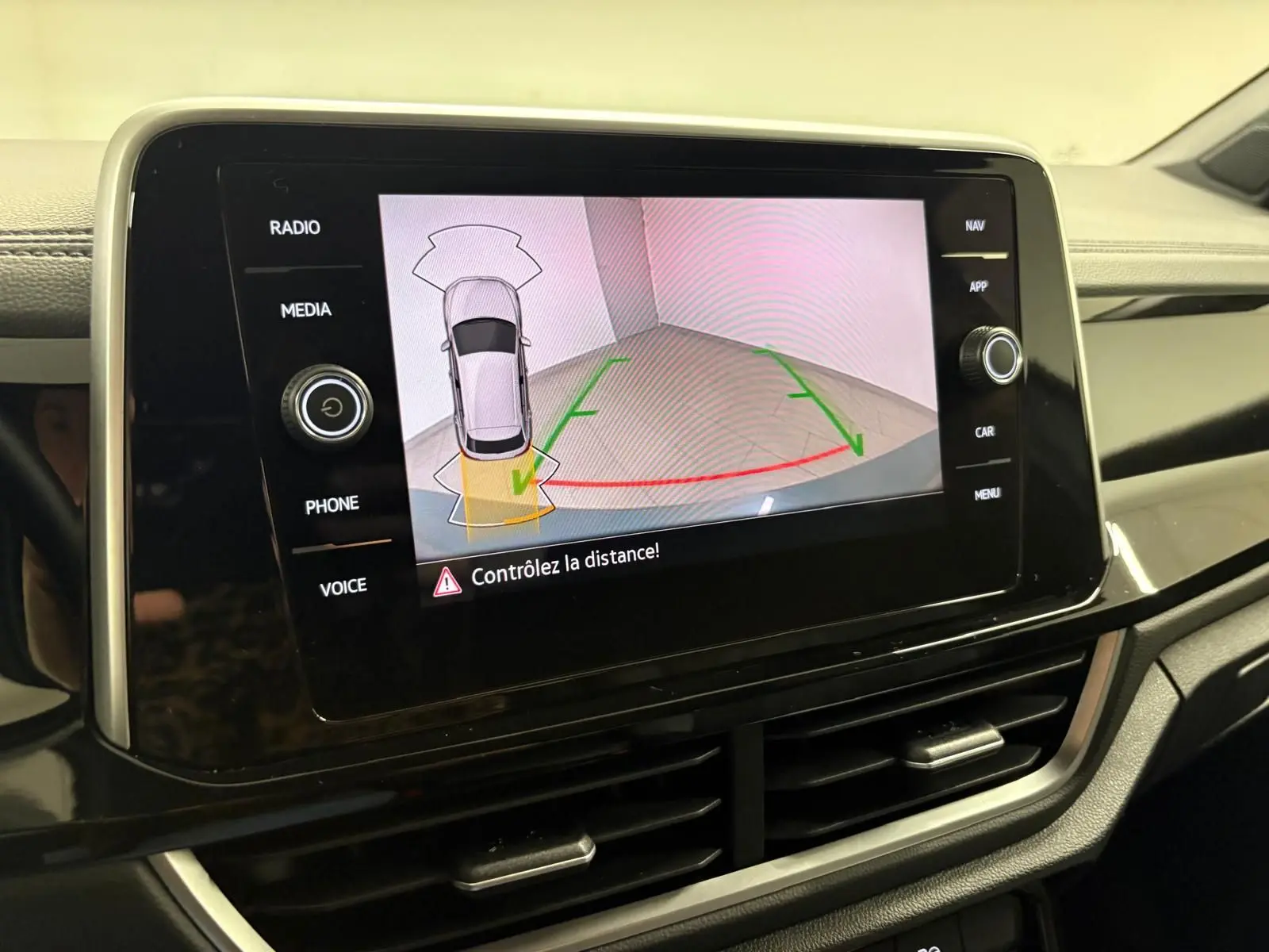 Écran central du Volkswagen T-Roc 2024 affichant la caméra de recul avec alertes de distance.
