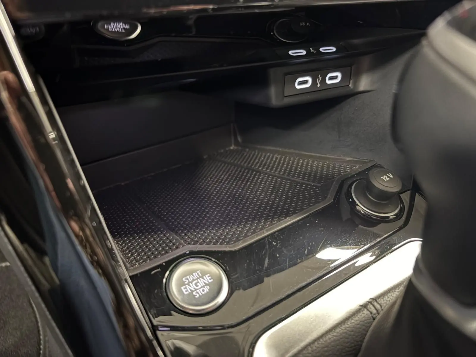 Gros plan sur la console centrale du Volkswagen T-Roc 2024, bouton Start Engine Stop et prises USB visibles.
