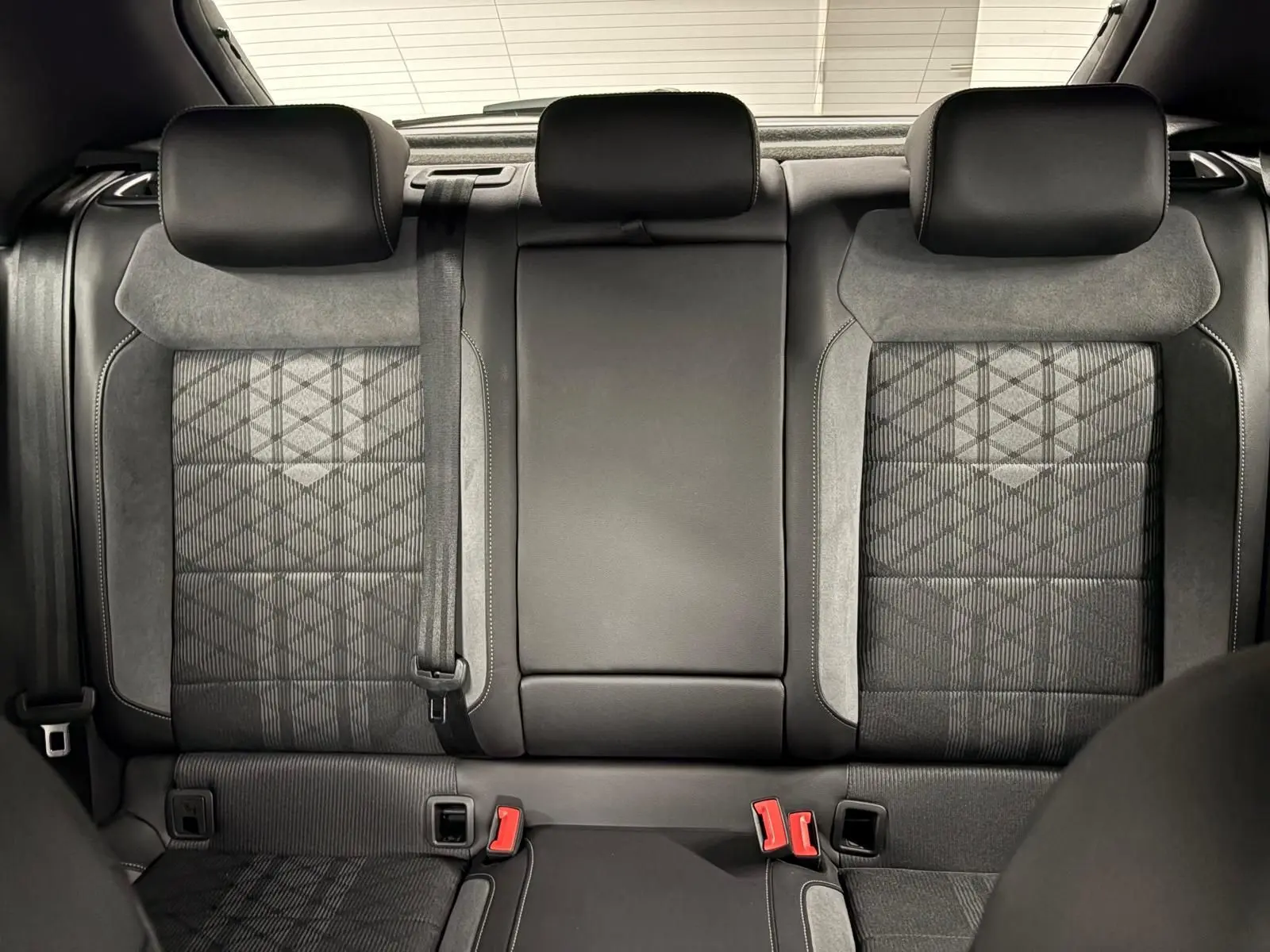 Vue intérieure sur les sièges arrière du Volkswagen T-Roc 2024, finition R-Line, avec sellerie noire et gris anthracite.
