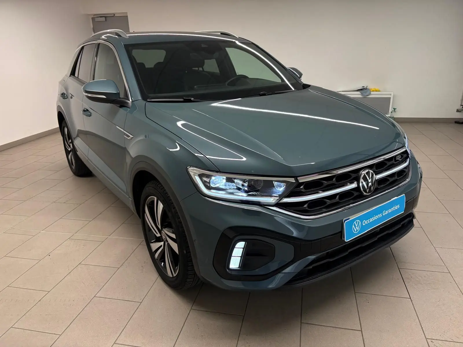 Volkswagen T-Roc 1.5 TSI R-Line bleu pétrole en 3/4 avant droit avec projecteurs Matrix LED allumés.