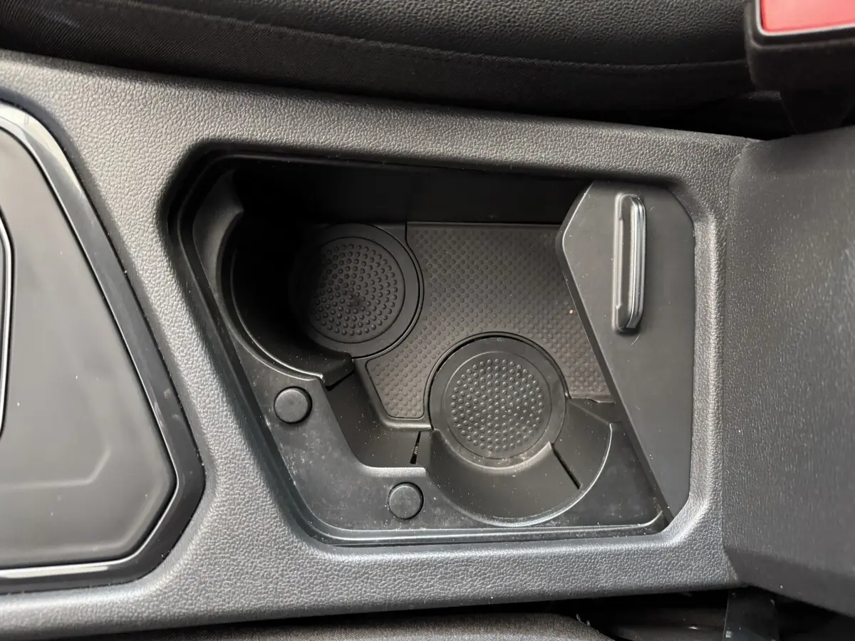Gros plan sur le porte-gobelets noir intégré au console centrale du Volkswagen Tiguan Allspace gris foncé.