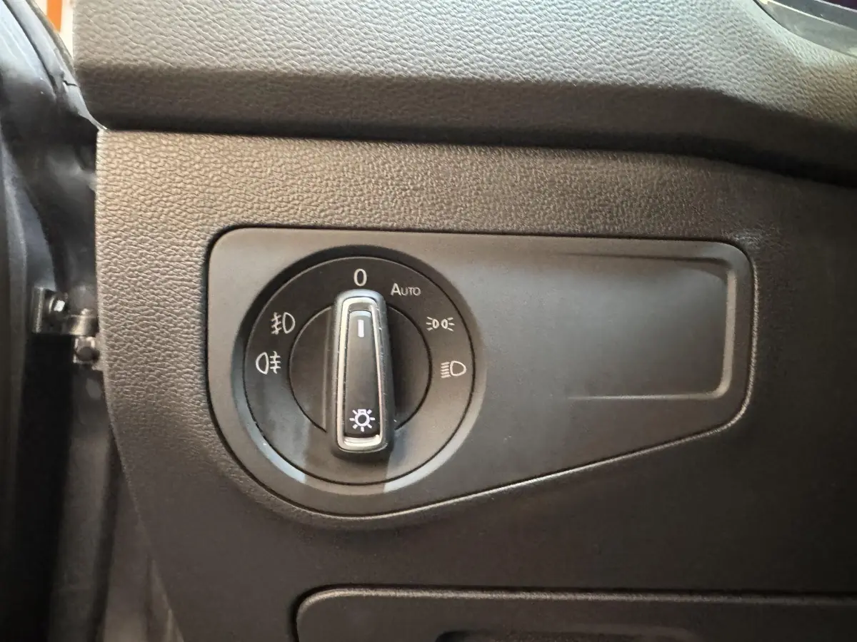 Gros plan sur le bouton de commande des phares du Volkswagen Tiguan Allspace gris foncé, intérieur côté gauche.