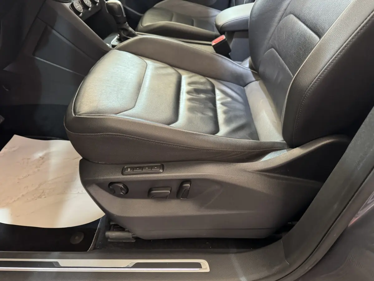 Gros plan sur le siège conducteur en cuir noir du Volkswagen Tiguan Allspace 2019, avec commandes électriques visibles.