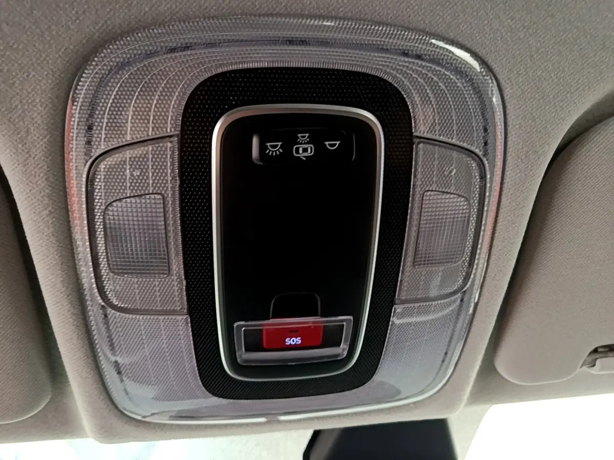 Vue en gros plan du plafonnier intérieur gris clair de la Hyundai i20 2022 avec bouton d'appel d'urgence SOS rouge.
