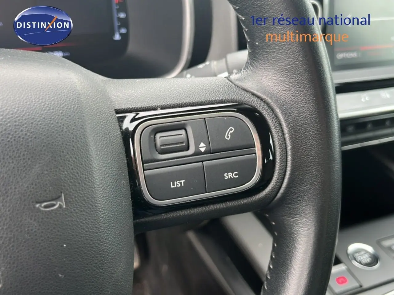 Gros plan sur les commandes au volant côté gauche du Citroën C5 Aircross gris clair métal, version PureTech 130ch Feel.
