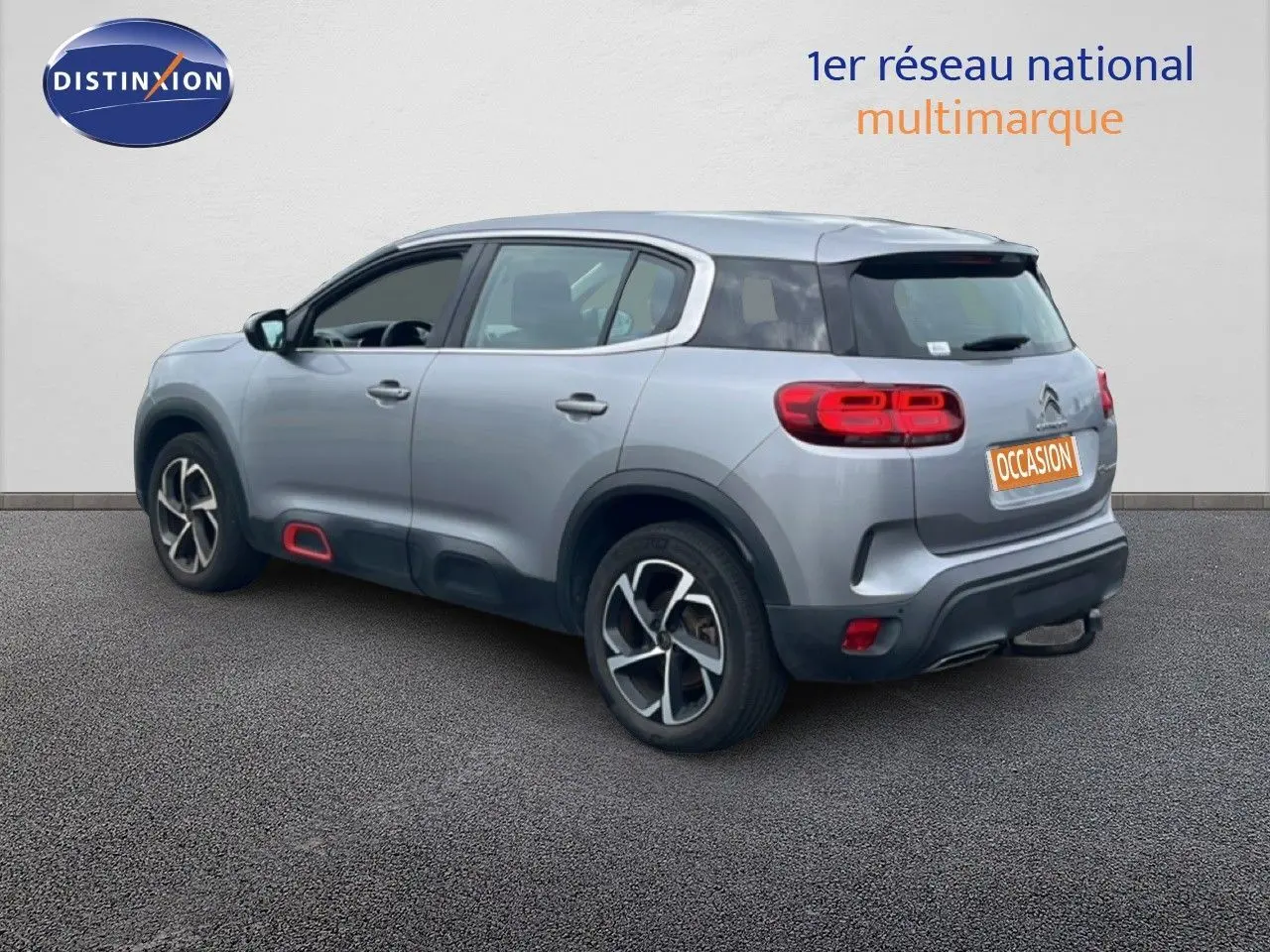 Vue 3/4 arrière droite d'un Citroën C5 Aircross gris clair métal avec feux arrière LED et jantes alliage.