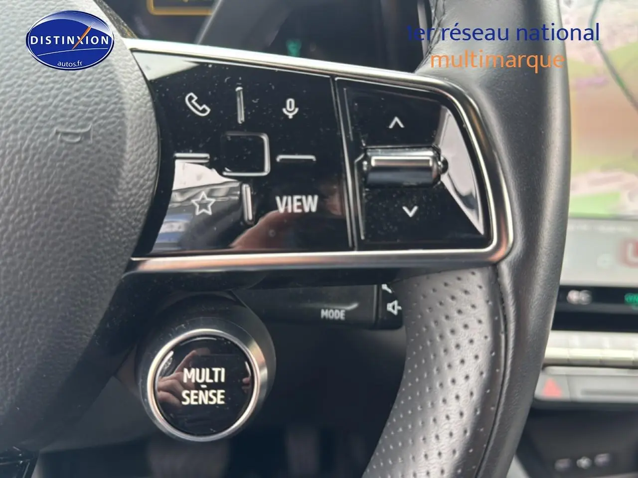 Gros plan sur le volant cuir perforé du Renault Austral gris schiste, avec commandes multifonctions et bouton Multi Sense.
