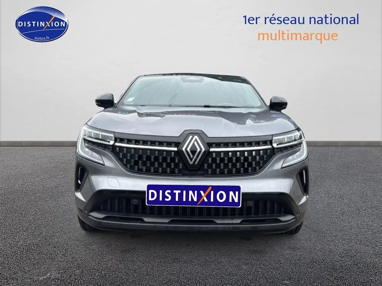 Vue avant du Renault Austral 2024 gris schiste avec calandre noire et logo central lumineux.