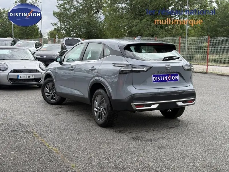 Vue 3/4 arrière droite d'un Nissan Qashqai gris Argile 2025 avec feux arrière LED et jantes alu.