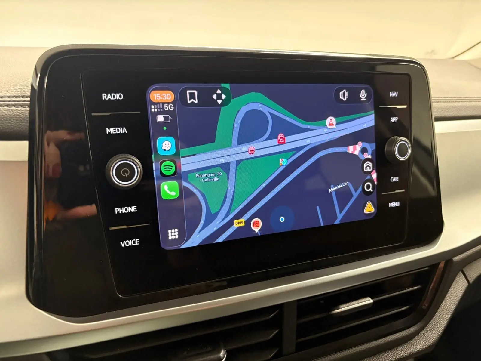 Écran tactile central du Volkswagen T-Roc 2024 affichant la navigation avec carte et commandes multimédia autour.