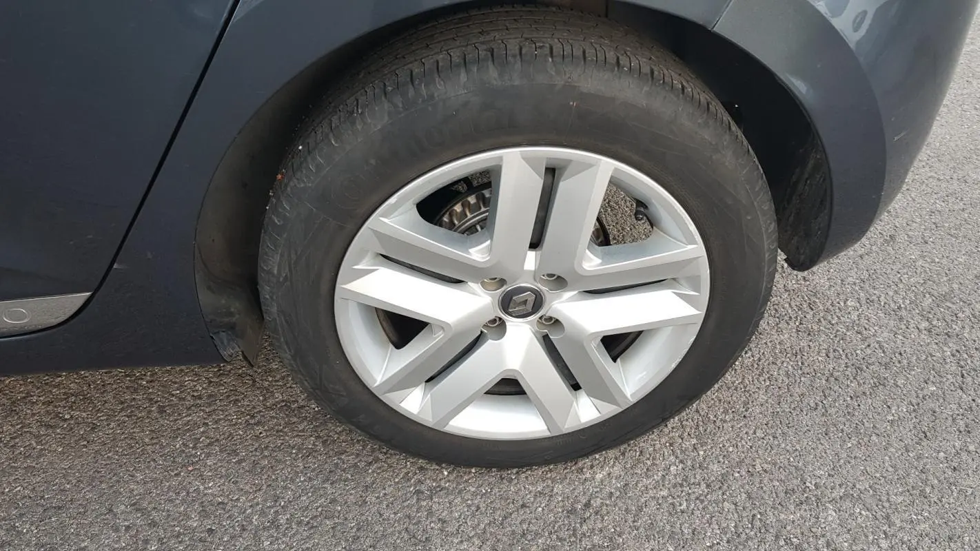 Gros plan sur la roue avant droite grise d'une Renault Clio V TCe 90 Business 2021 avec jante en alliage.