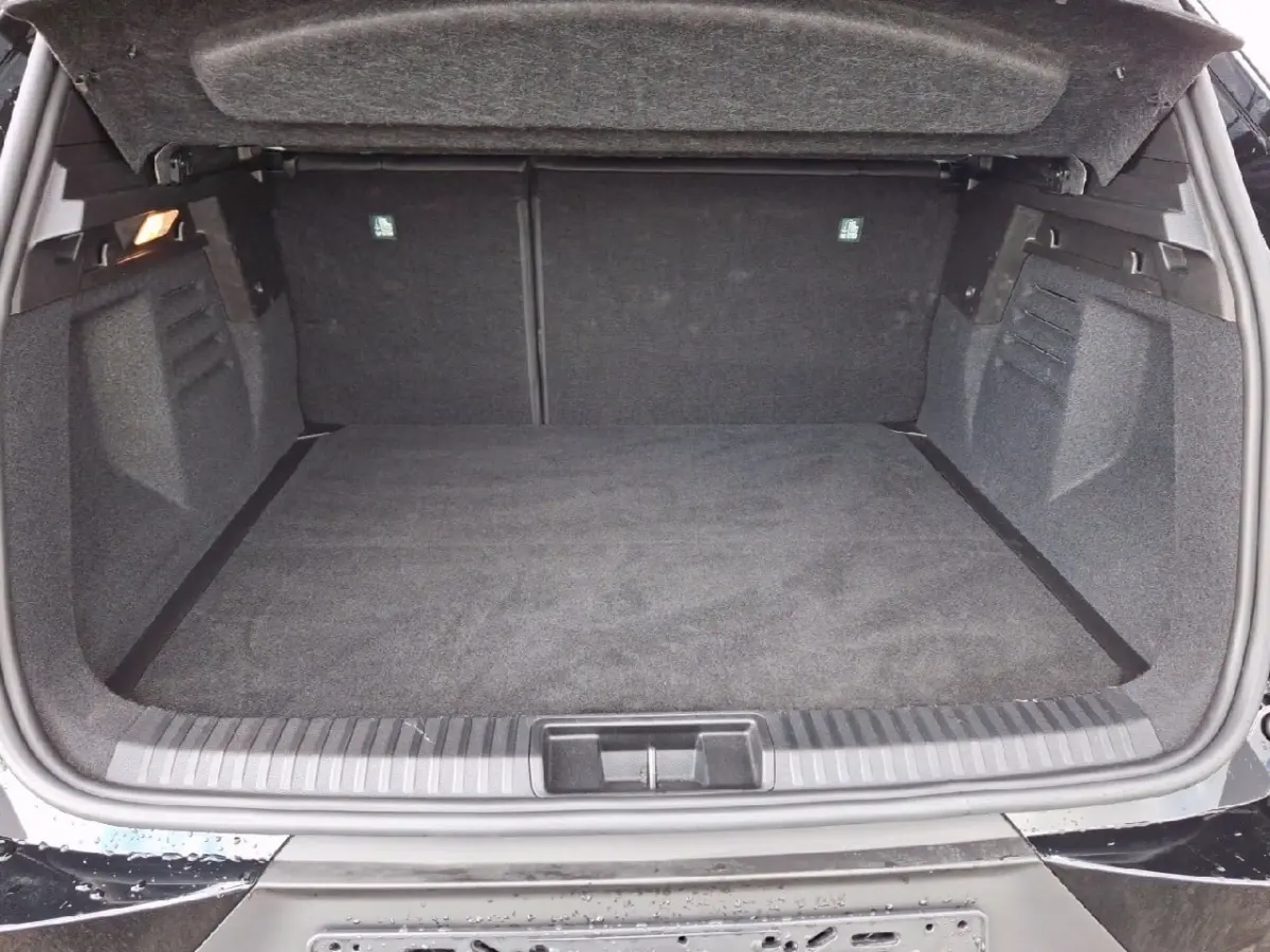 Coffre ouvert vu de l'arrière d'une Renault SYMBIOZ noire, espace de chargement propre et spacieux.