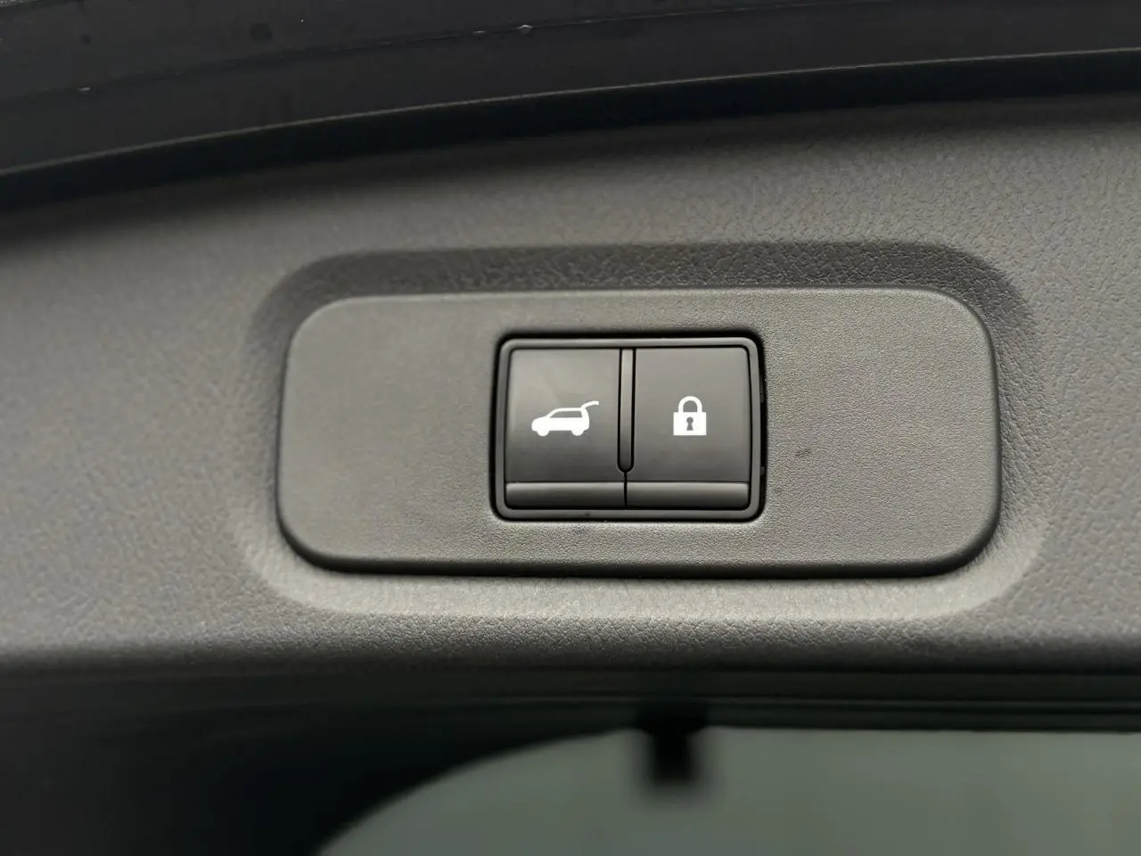 Gros plan sur les boutons d'ouverture et de verrouillage du hayon électrique du Nissan Qashqai gris Squale.