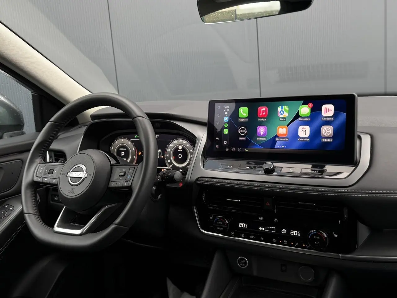 Vue intérieure côté conducteur du Nissan Qashqai 2024, tableau de bord noir avec écran tactile et affichage numérique.