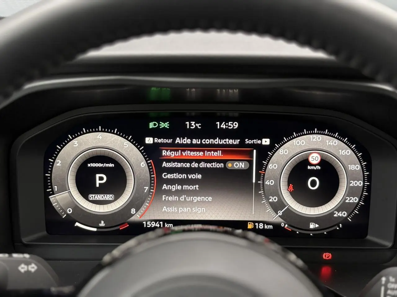Vue rapprochée du combiné d'instrumentation numérique du Nissan Qashqai 2024 affichant les aides à la conduite et la vitesse à 0 km/h.