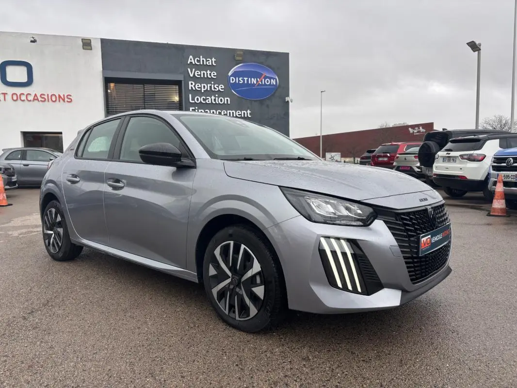 Peugeot 208 Hybrid gris vue 3/4 avant droit, avec feux diurnes verticaux et jantes 16 pouces distinctives.