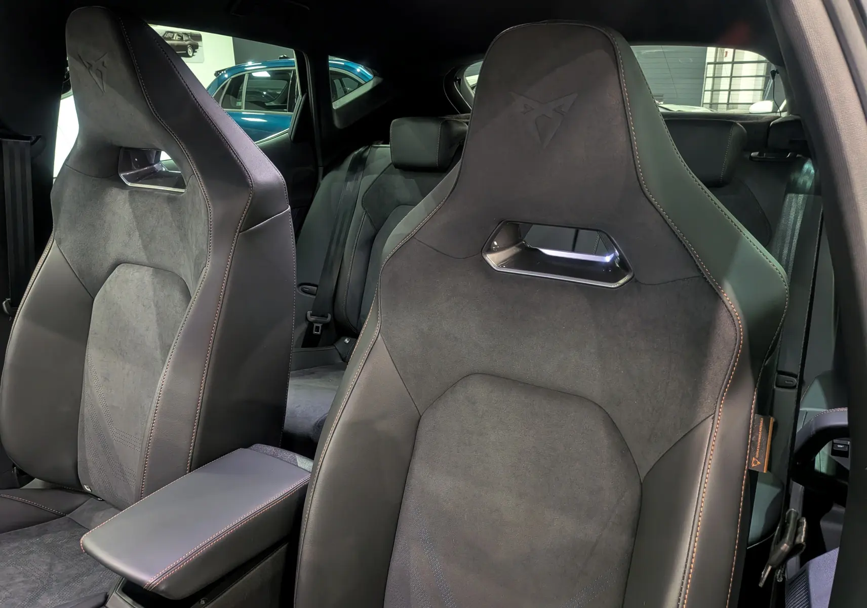 Vue rapprochée des sièges avant en cuir noir et alcantara du CUPRA Formentor eHybrid 2025 avec logo embossé et surpiqûres contrastées.