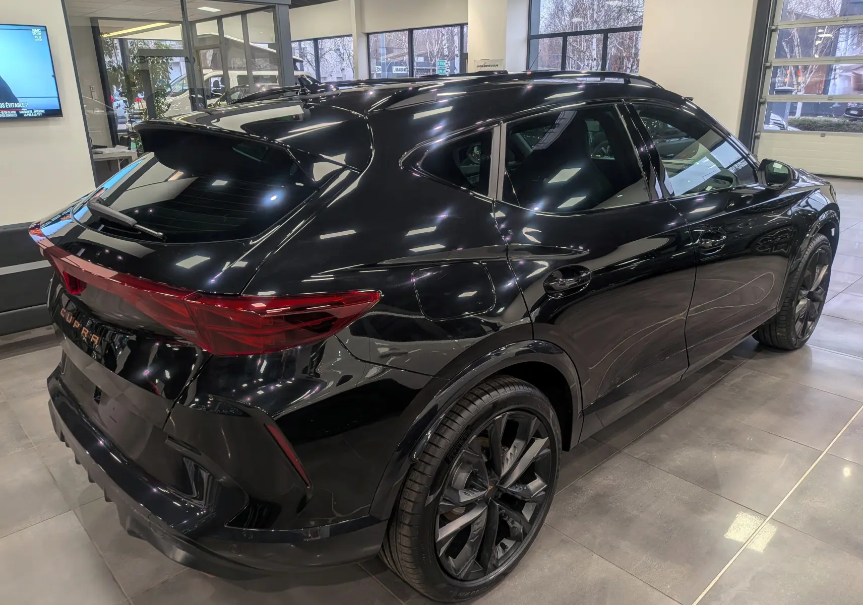 Vue 3/4 arrière droite du CUPRA Formentor eHybrid noir minuit, soulignant ses jantes noires et son design dynamique.