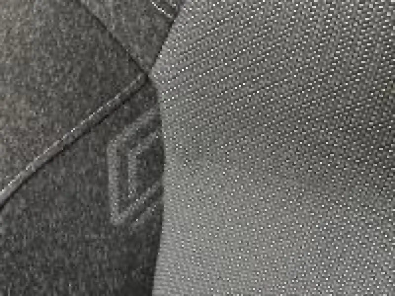 Intérieur du Renault Captur 2025 Techno, vue rapprochée sur le siège avant avec tissu gris texturé.