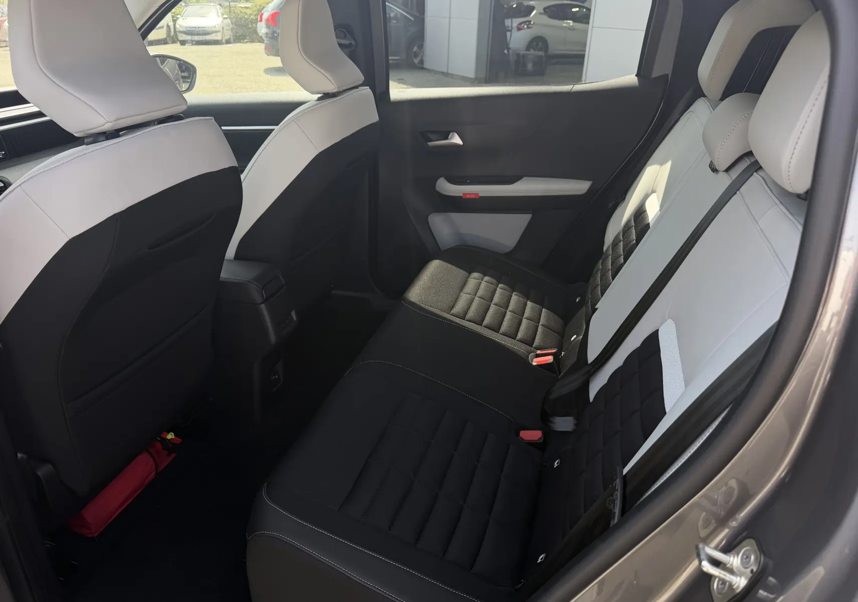 Banquette arrière bicolore beige et noir du Citroën C3 Aircross électrique 2025, vue intérieure depuis l'avant.