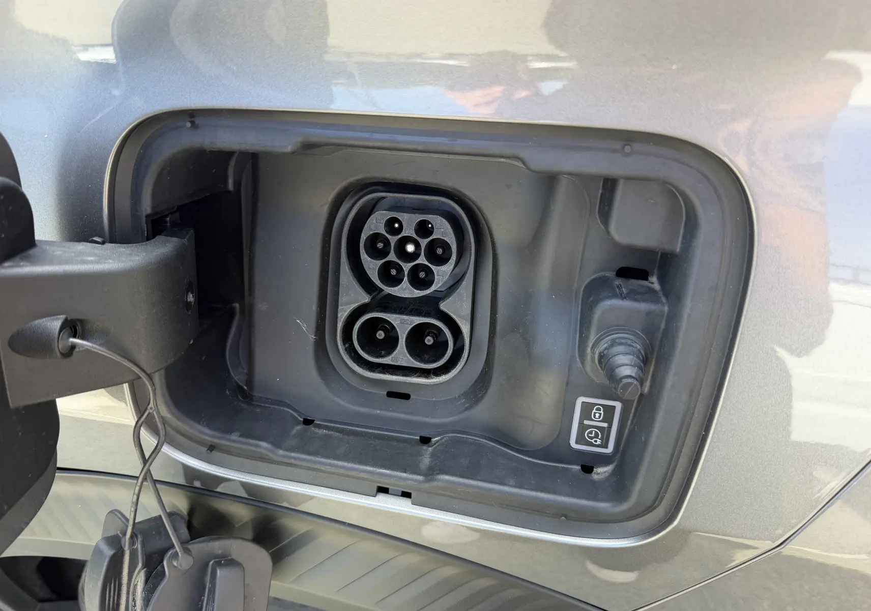 Vue intérieure côté arrière droit du Citroën C3 Aircross gris foncé, sièges bicolores noir et blanc avec surpiqûres.