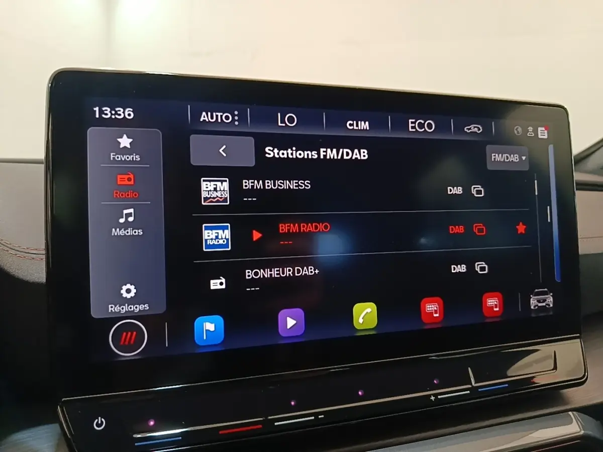 Écran tactile central affichant les stations radio FM/DAB dans l’habitacle du CUPRA Formentor noir, vue rapprochée.
