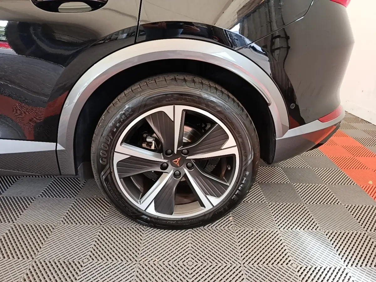 Gros plan sur la roue arrière droite noire du CUPRA Formentor 1.4 e-HYBRID 2024 avec jante alu bicolore et logo CUPRA central.