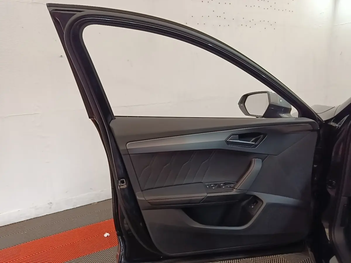 Vue intérieure de la porte avant gauche noire du CUPRA Formentor 2024 avec garniture en cuir et commandes intégrées.