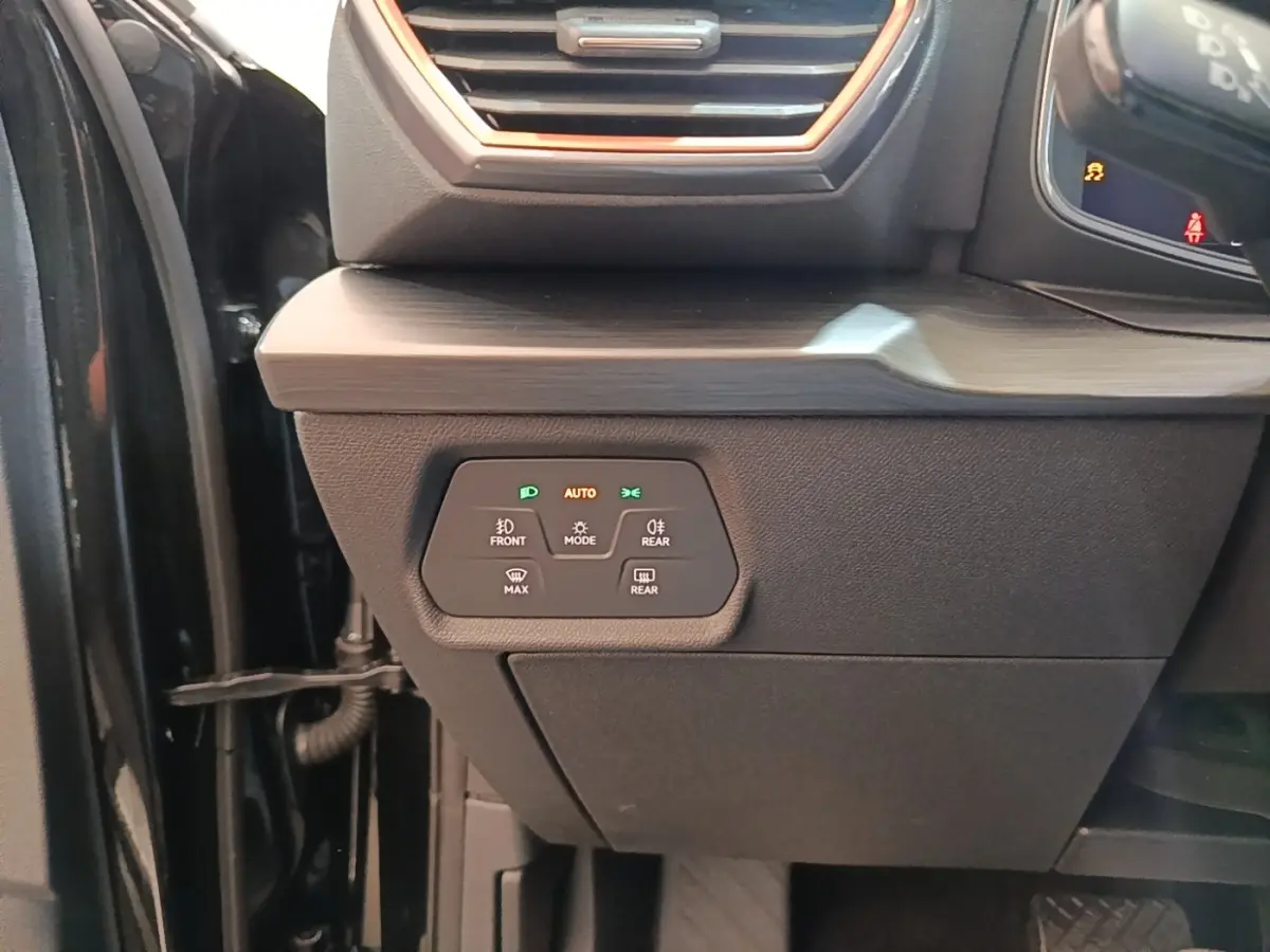 Détail du tableau de bord côté gauche d'une CUPRA Formentor noire, avec commandes d'éclairage et ventilation visibles.