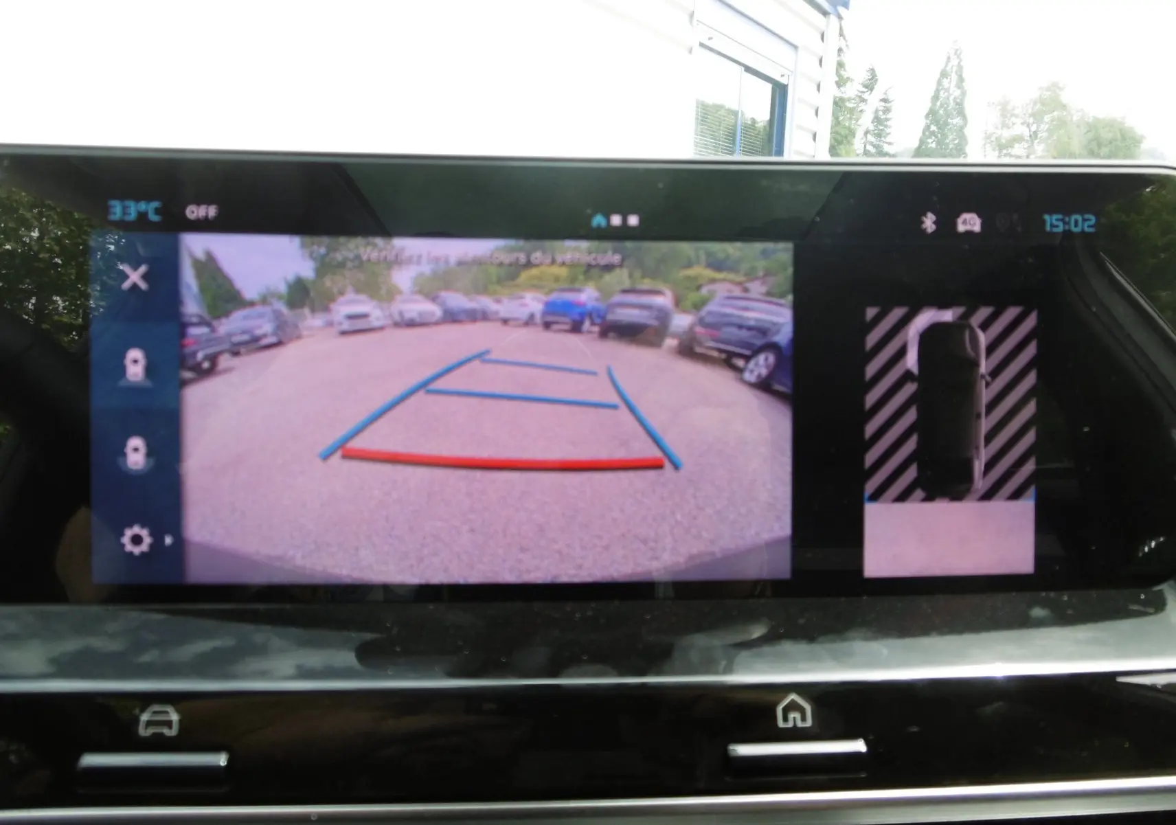 Écran de caméra de recul du Citroën C4 X blanc polaire, affichant l'angle arrière avec lignes de guidage colorées.