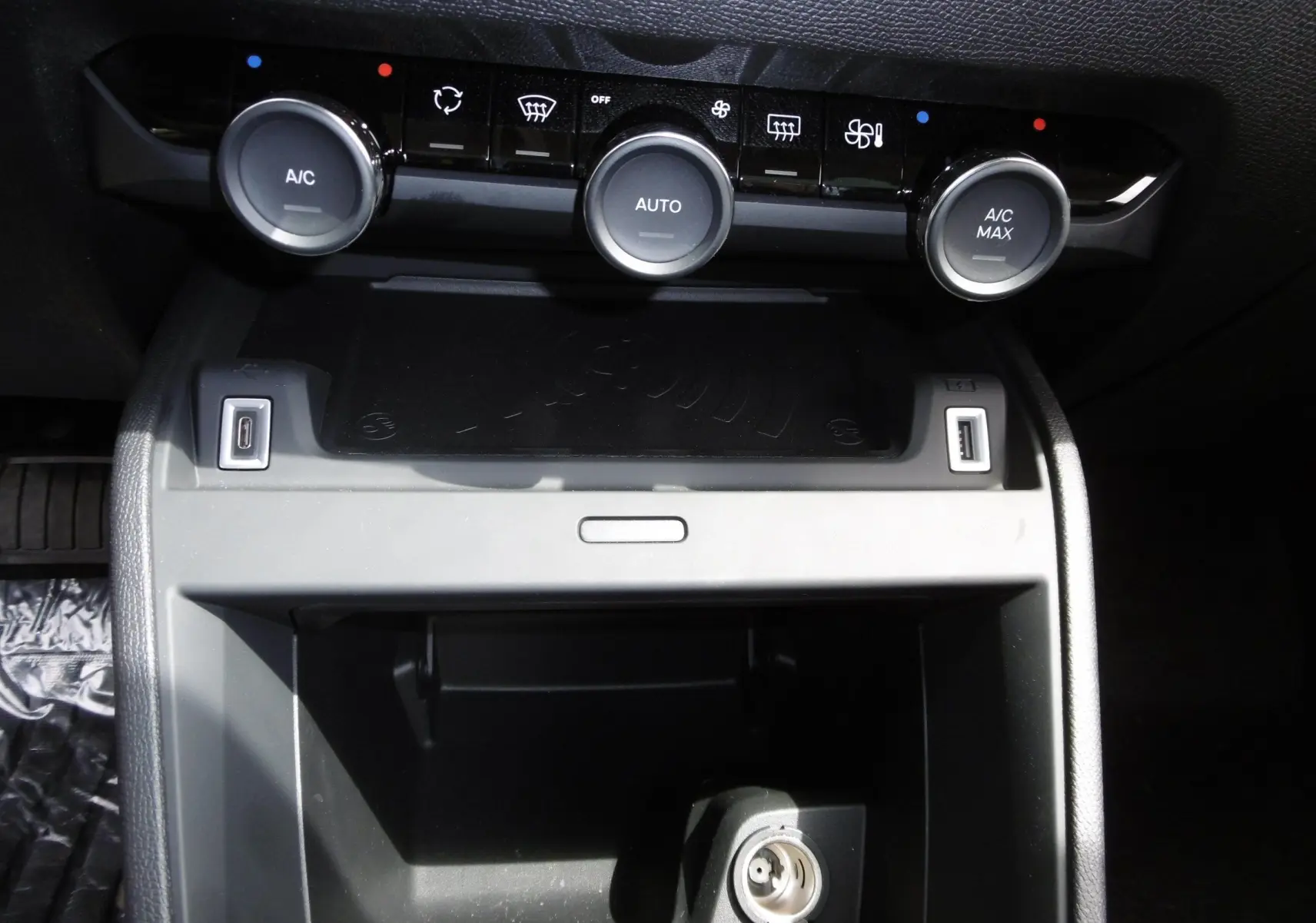 Détail de la console centrale de la Citroën C4 X blanche 2023 avec commandes climatisation et ports USB visibles.