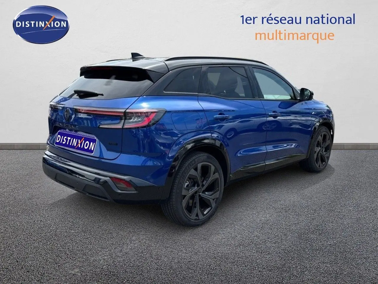 Vue 3/4 arrière droite d'un Renault Austral 2024 bleu Iron avec toit noir et jantes noires distinctives.