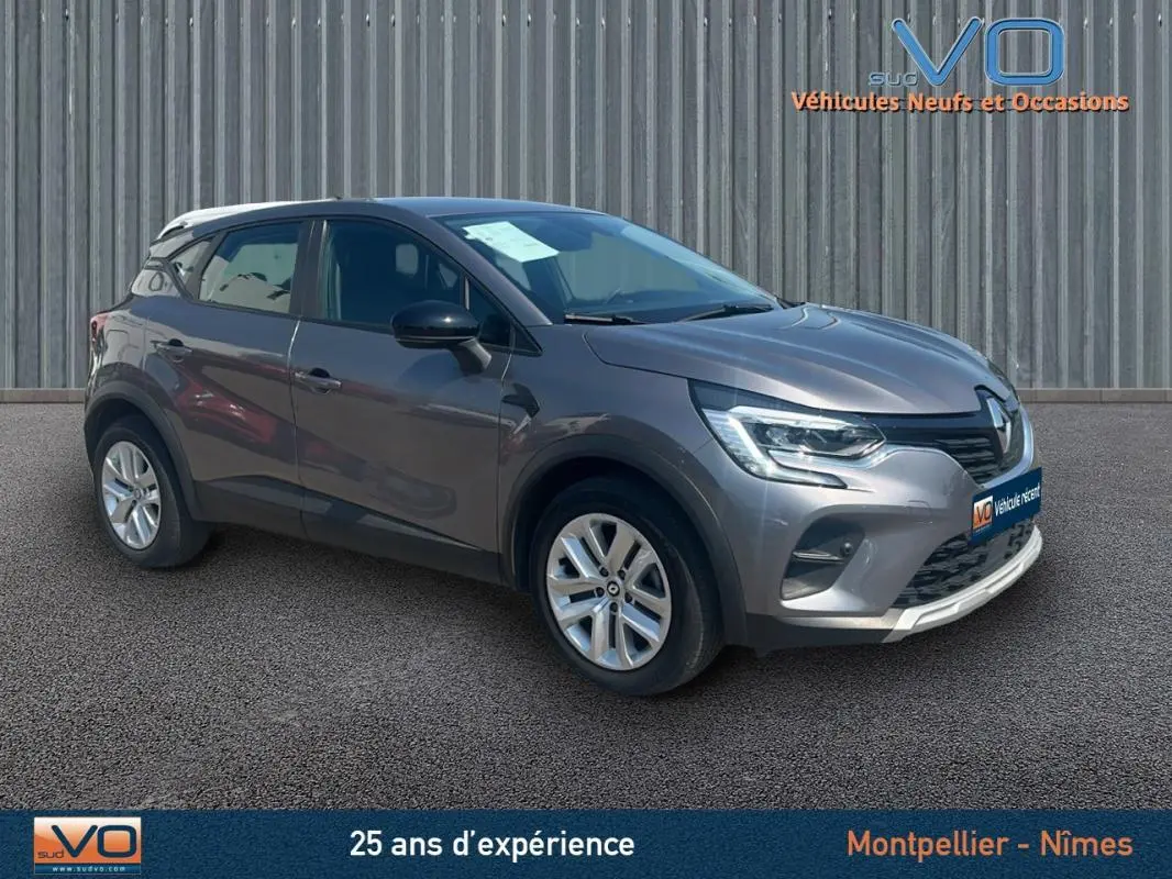 Renault Captur TCe 90 Business gris vu en 3/4 avant droit, avec jantes argentées et calandre noire brillante.